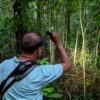Tour guide Freddy searching for tapirs in a secondary forest at dusk