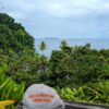 A 'Link Expeditions' hat on a bench with the forest, ocean, and El Caño Island in the background