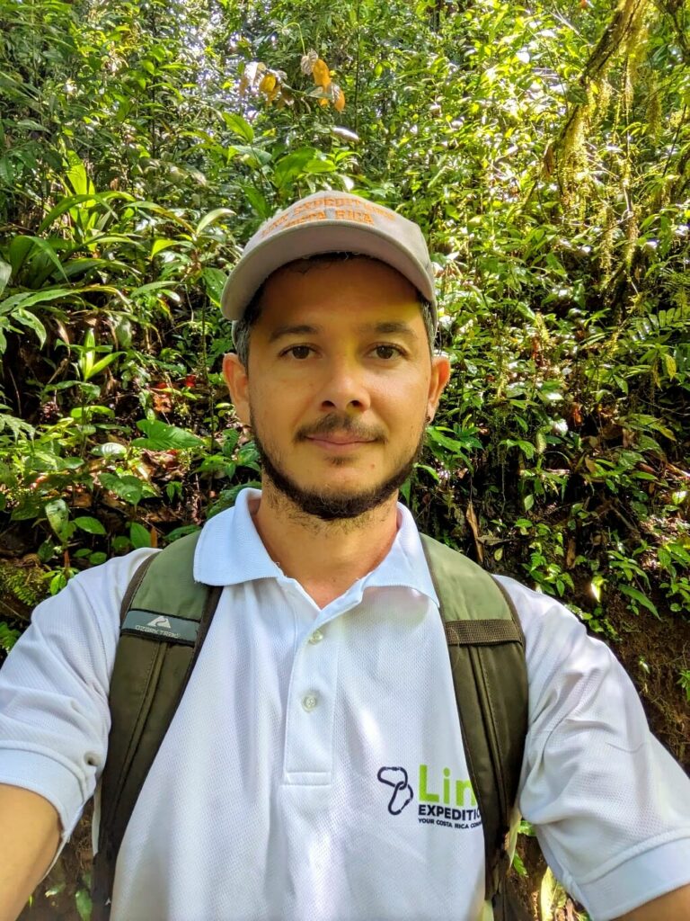 mage of Alberto Salas Costa Rica walking through the rainforest carrying his backpack, an expert and avid travel advisor, founder of Link Expeditions.