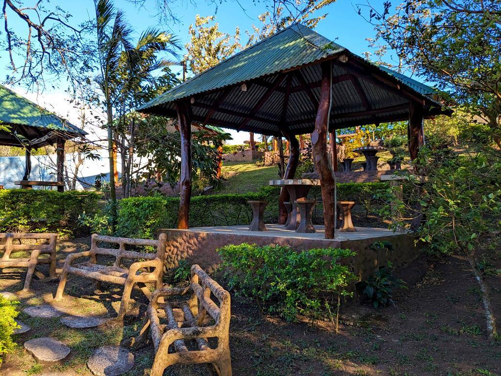 Bench seating for relaxation near hot springs in Bijagua, Costa Rica, with a rustic open structure offering picnic amenities to extend the leisurely visit.