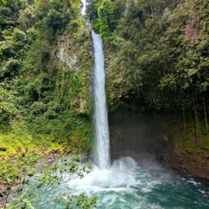 Vertical view of La Fortuna Waterfall, emphasizing its height, pool, and lush surroundings.