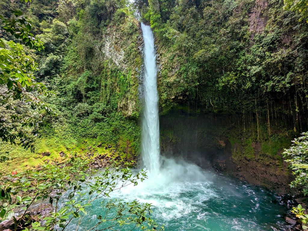 General view of La Fortuna Waterfall, showcasing its height, size, pool, and verdant surroundings.