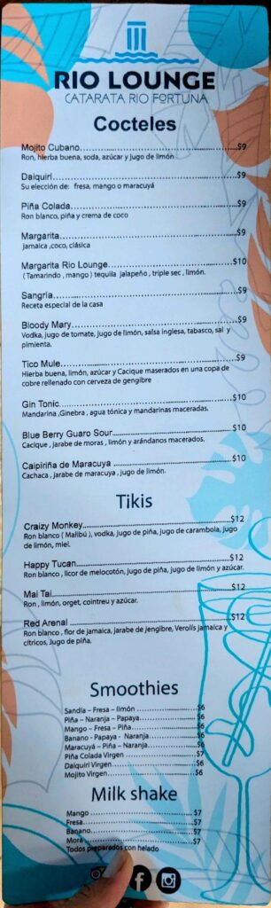 Drinks menu at Rio Lounge restaurant by the entrance of La Fortuna Waterfall, offering cocktails, smoothies, and milkshakes.