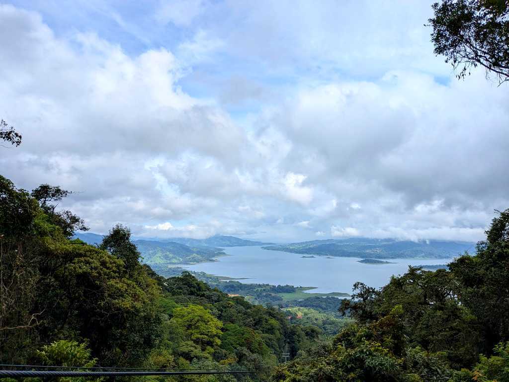 Panoramic view of Arenal Lake with surrounding lush rainforest.