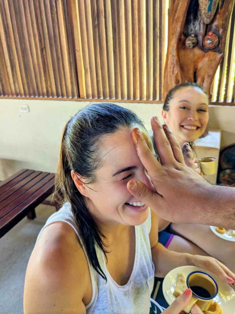 Travelers smile as they learn about artisan pottery making and enjoy coffee and traditional Guanacastecan snacks.