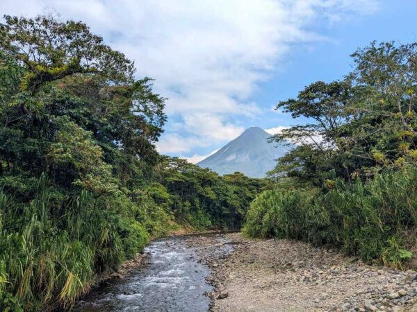 View of Agua Caliente River, lush riparian forest, and the towering Arenal Volcano from Shailee's Arenal Volcano View Point.