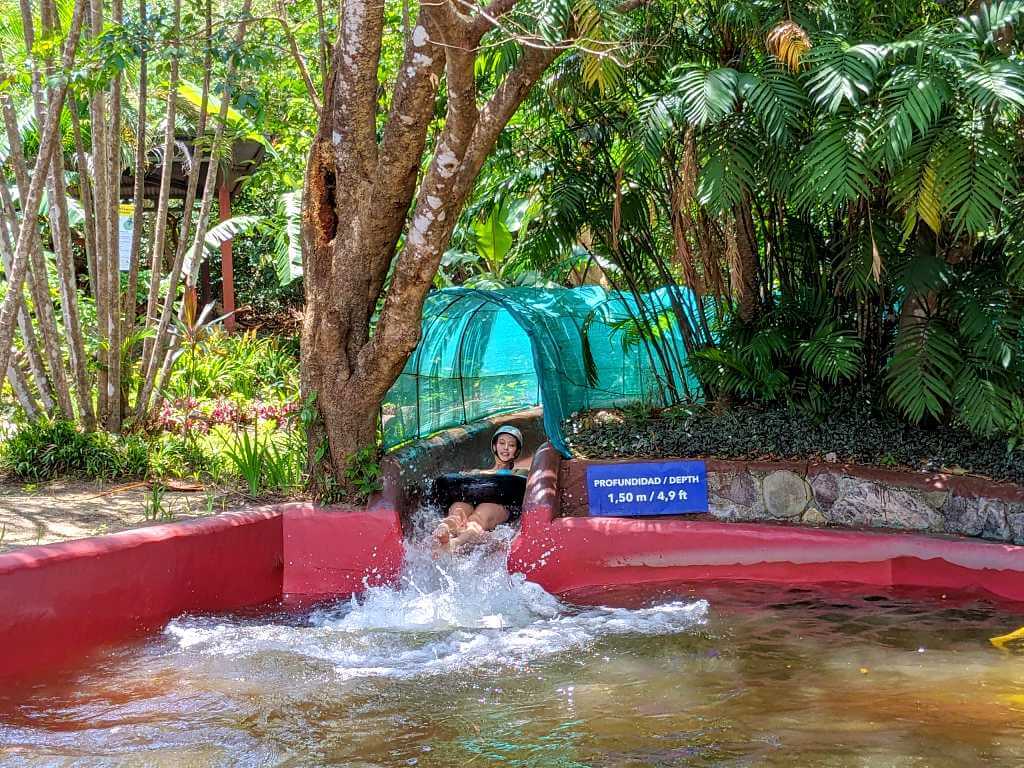 Traveler reaching the end of the water slide at Buena Vista del Rincón, splashing into a freshwater pool 1.5 meters deep.