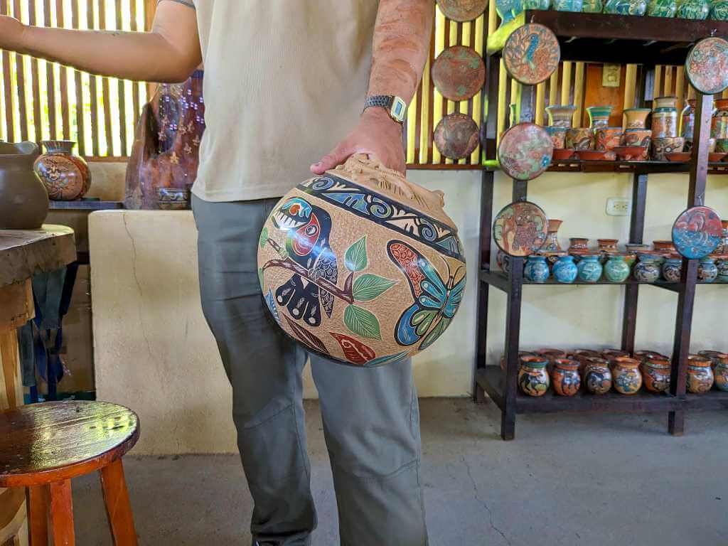 Tour guide showing pottery made by a member of the Guaitil community using ancestral techniques at Buena Vista.