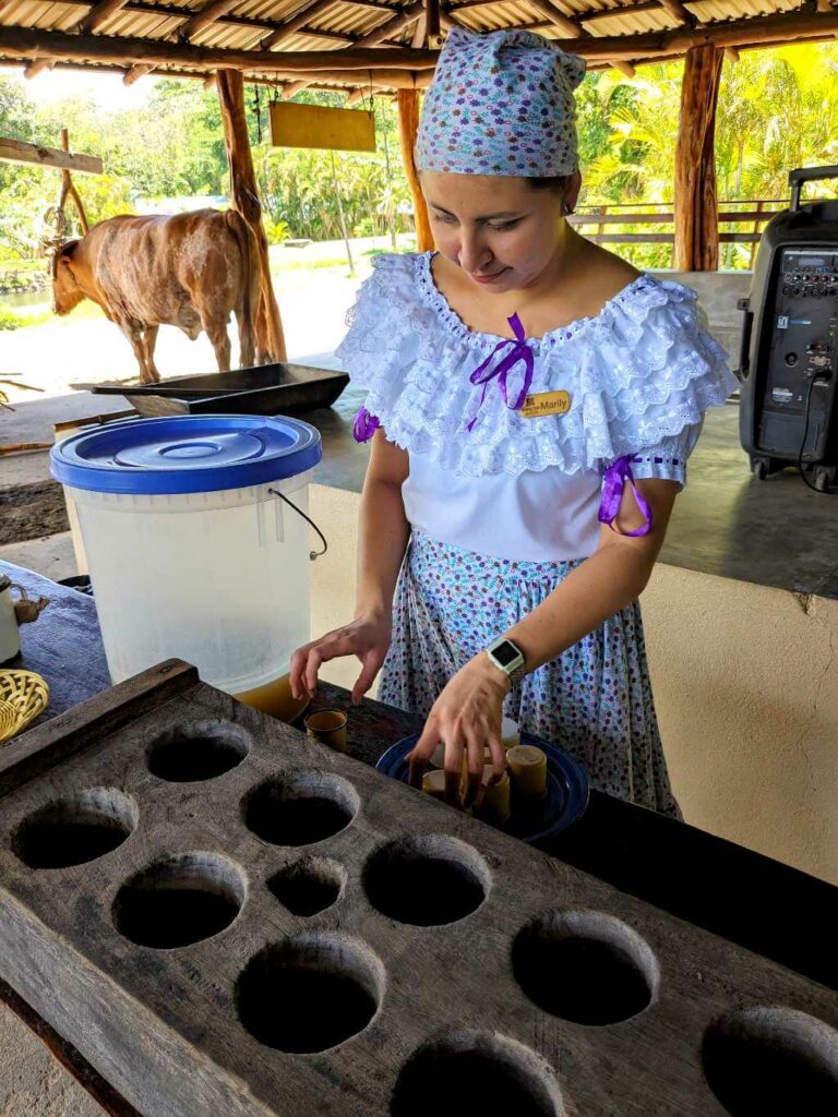 Costa Rican woman showing traditional molds for making tapa de dulce, unrefined sugar blocks.