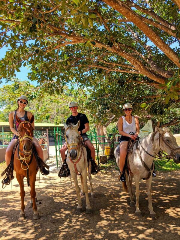 Three travelers posing on horseback before starting a tour at Buena Vista del Rincón in Guanacaste, Costa Rica.