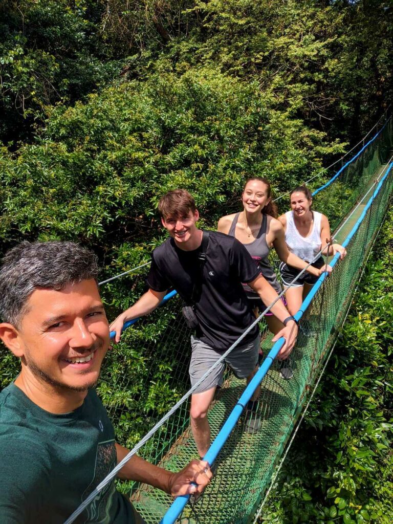 Tour guide and travelers exploring the Los Higuerones Hanging Bridges at Buena Vista del Rincón, Guanacaste, Costa Rica.