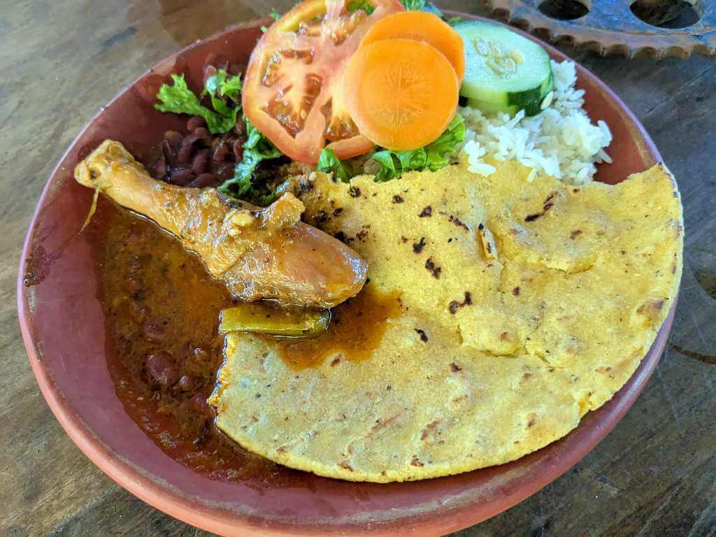 Casado con Tortilla, a typical Costa Rican dish with rice, beans, salad, plantains, and meat served with a homemade tortilla, showcasing Costa Rican cuisine.